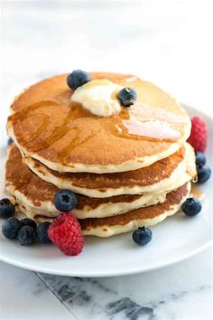 a stack of pancakes topped with blueberries and butter