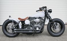 a black and white motorcycle parked in front of a garage door