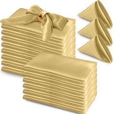 a stack of gold colored napkins with a bow on the top and one folded