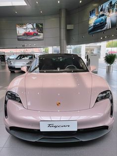 a pink sports car is on display in a showroom