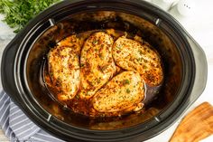 chicken in a slow cooker with parsley on the side