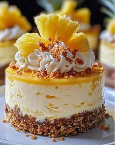 there is a small cake with pineapples and whipped cream on top, sitting on a plate