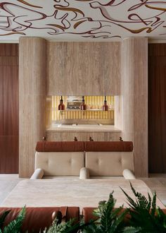 the interior of a modern hotel lobby with wood paneling and marble counter tops, along with plant life