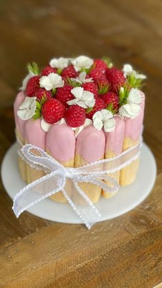 a cake decorated with strawberries and flowers on a plate