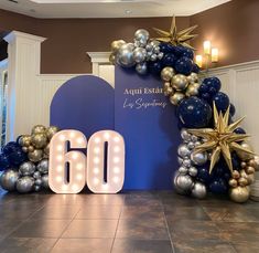 the entrance to an event decorated with balloons and star garlands in blue, silver and gold colors