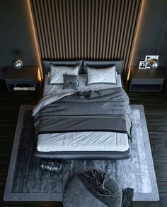 a large bed sitting on top of a wooden floor next to a night stand with two lamps