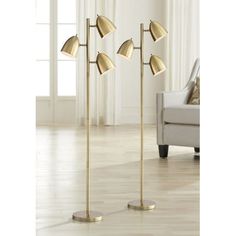 three brass colored floor lamps in a living room