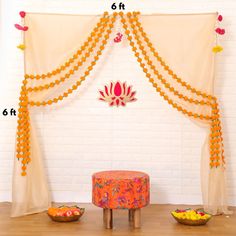 a decorated stage with orange and yellow decorations on it's sides, along with bowls of fruit in the foreground