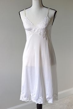 Embrace timeless elegance with this vintage 80s white midi slip dress, featuring delicate white lace trim for a touch of romance. Perfect as retro bridal lingerie, feminine nightwear, or a dreamy cottagecore piece, this slip dress is a versatile addition to any vintage lover's wardrobe. Made from soft, lightweight fabric, it drapes beautifully, offering both comfort and style. Ideal for layering under dresses or wearing on its own for a minimalist look. This unique piece is a must-have for those who appreciate classic fashion with a vintage twist. Fits a size small - medium. Message for measurements. Ms Hannigan, Feminine Nightwear, Dreamy Cottagecore, Retro Bridal, Slip Dress With Lace, Dress With Lace Trim, White Slip Dress, Style Cottage, Lace Trim Dress