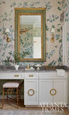 an ornate bathroom with floral wallpaper and gold accents, including a large mirror above the sink