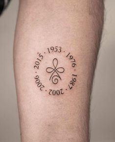 a man with a tattoo on his leg that reads, date 2009 - 2013 and has a cross in the middle