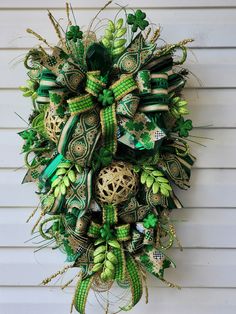 a green and gold wreath hanging on the side of a house