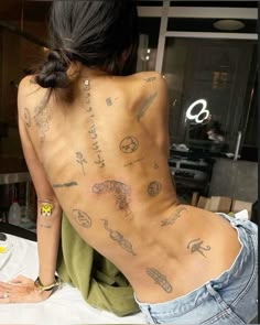 a woman with many tattoos on her back