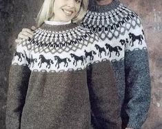 a man and woman standing next to each other wearing sweaters with horses on them