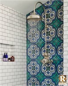 a shower head and hand held shower faucet in front of a tiled wall