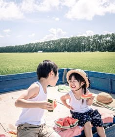 two children sitting in the back of a truck eating watermelon