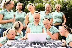 a group of women in green shirts standing around a table