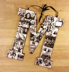 the letter m is made out of photos and tied to a wooden table with a black ribbon