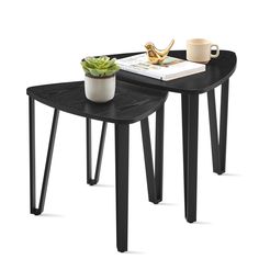 two tables with black legs and a potted plant on the top one has a book