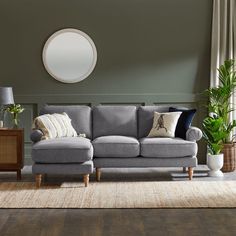 a living room filled with furniture and a round mirror on the wall above it's headboard