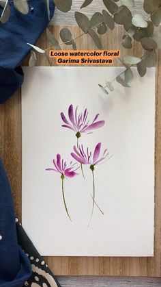 purple flowers on white paper next to blue cloth and plant leaves with text overlay that reads loose watercolor floral canvas art