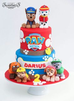 a three tiered cake decorated with paw patrol characters