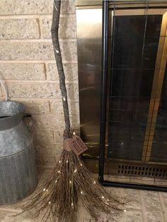 a broom sitting on top of a tile floor next to a metal trash can