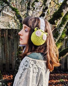 a woman wearing a crocheted headband with an owl on it's ear