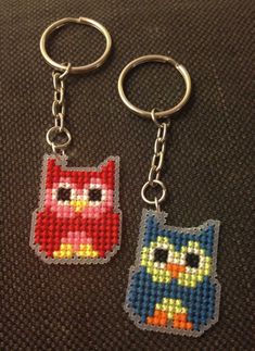 two key chains with an owl and cat design on them