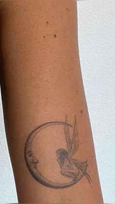 a woman's arm with a tattoo on it and a bird flying over the moon