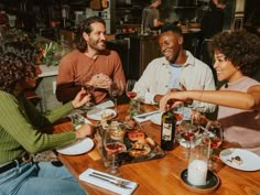 four people sitting at a table with food and drinks