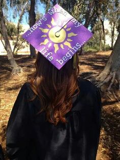 a woman wearing a purple graduation cap with the sun on it