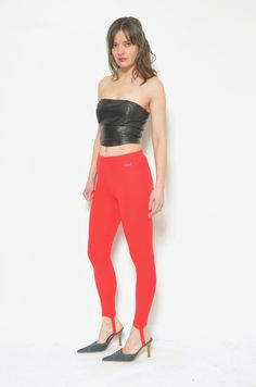 "These vintage 80s stirrup pants are a fun and funky pair of high waisted red leggings that will make you stand out from the crowd. They are made of stretchy polyester blend fabric that hugs your body and feels smooth on your skin. The pants feature a stirrup design that hooks under your feet, creating a sleek and seamless look. They have an elastic waistband that ensures a comfortable fit. These pants are great for layering, dancing, or lounging. They are in very good condition, with no stains, tears, or holes. They are a size small, with the following measurements: - Label: Wings (made in Holland) - Era: 1980's - Color: red - Fabric: 100%  poliamid  - Condition: very good. Ready to wear. - Tag Size: 36 - Fits size: small MEASUREMENTS: Waist: 23\" (60 cm) elastic Length: 32\"(81 cm) Model Red Stretch Elastane Leggings, Red Fitted Casual Leggings, Casual Red High Stretch Tights, Tight Red Elastane Leggings, Red High Stretch Full Length Tights, Casual Full-length Red Tights, Casual Red Full-length Tights, High Waist Stretch Red Tights, High-waist Stretch Red Tights