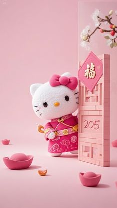 a hello kitty doll standing next to a pink wall