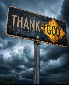 a black and yellow street sign with the words thank god written on it under a cloudy sky