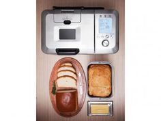 a toaster oven sitting on top of a wooden table next to bread and butter