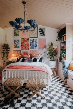 a bed room with a neatly made bed and lots of pictures on the wall behind it