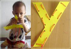 a young child holding a yellow paper letter y with the letter y in front of it