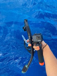 someone is holding up a camera to take a photo in the water with their scuba gear