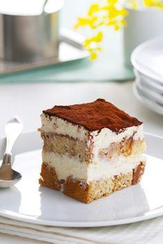 a piece of cake sitting on top of a white plate next to a fork and spoon