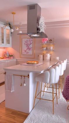 a kitchen with white counter tops and gold accents