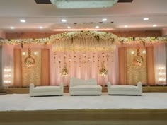 a stage set up with couches and chandelier for a wedding reception at the hotel