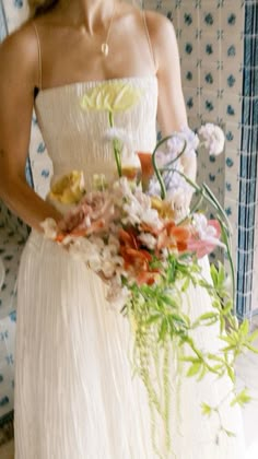 a woman in a white dress holding a bouquet of flowers