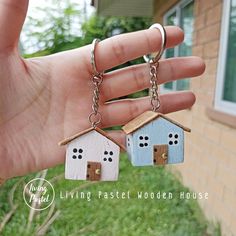 two small houses are hanging from a hand