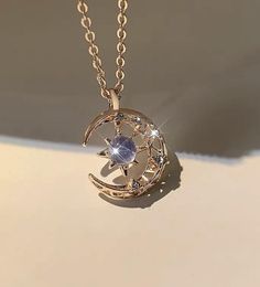 Elevate your style with our enchanting Moon & Star Pendant Necklace, a perfect blend of celestial charm and timeless elegance. This stunning necklace features a crescent moon and star design, meticulously crafted in two exquisite finishes: lustrous gold and shimmering silver. Key Features: - Design: The pendant showcases a delicate crescent moon cradling a radiant star, symbolizing dreams and guidance. The moon is adorned with intricate detailing, and the star is set with a sparkling cubic zirconia stone at its center, mimicking the beauty of a twinkling star in the night sky. - Material: Made with high-quality materials, the pendant is available in both gold-tone and silver-tone finishes, ensuring durability and lasting shine. The central stone is a stunning blue cubic zirconia, adding a Elegant Star-shaped Sun And Moon Necklace, Celestial Rose Gold Necklace With Moon Phase, Rose Gold Celestial Necklace With Moon Phase, Elegant Crescent Jewelry With Star Charm, Celestial Rose Gold Moon Phase Necklace, Celestial Crescent Rose Gold Necklace, Celestial Rose Gold Necklace With Moon Charm, Elegant Moon-shaped Necklace With Star Charm, Elegant Moon Shaped Necklace With Star Charm