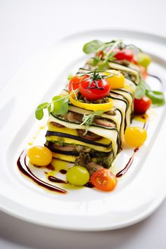 a white plate topped with lots of different types of food on top of each other