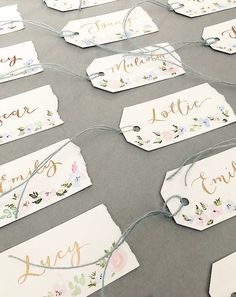 some tags that have been tied together with twine on the table and are decorated with flowers