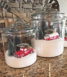 three glass jars with snow and cars in them