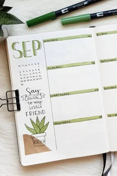 an open planner with markers and pens on it