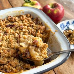 a casserole dish with apples and granola in it on a wooden table